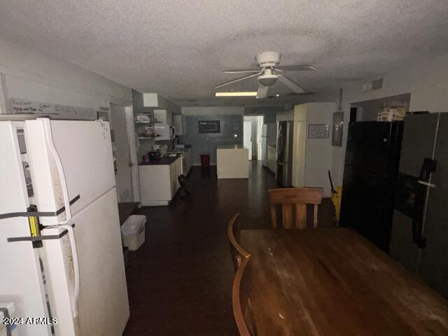 kitchen featuring white cabinetry, stainless steel fridge, white fridge, ceiling fan, and a textured ceiling