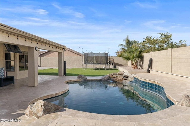 view of pool with a trampoline and a patio area