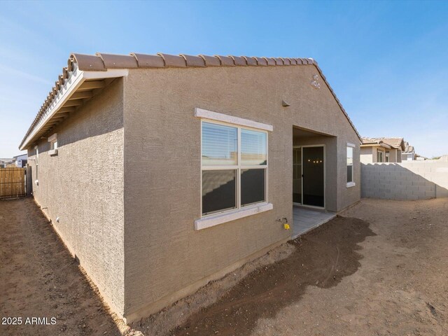 view of property exterior with fence and stucco siding