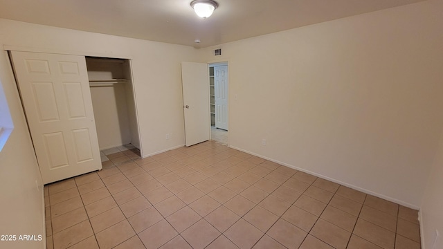 unfurnished bedroom with a closet and light tile patterned flooring