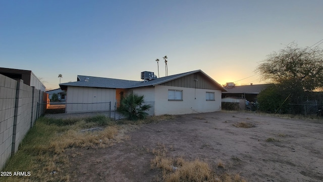 back house at dusk featuring central air condition unit