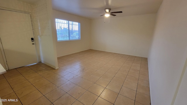 unfurnished room with light tile patterned floors and ceiling fan