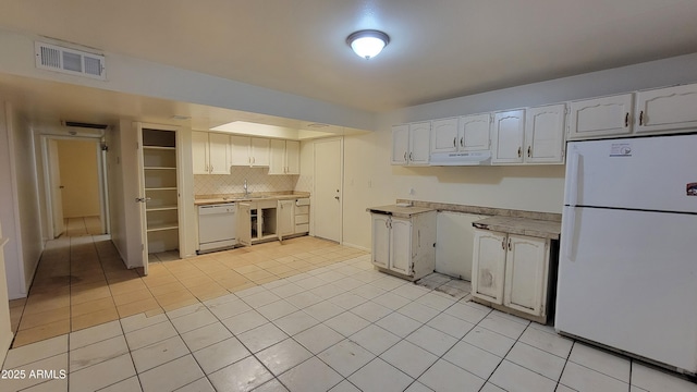 kitchen featuring light tile patterned flooring, backsplash, white cabinets, and white appliances