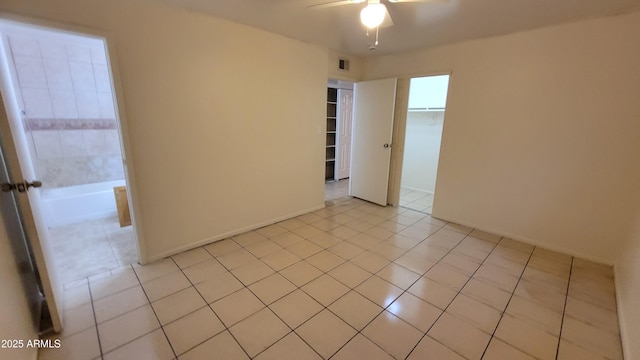 unfurnished room with ceiling fan and light tile patterned floors