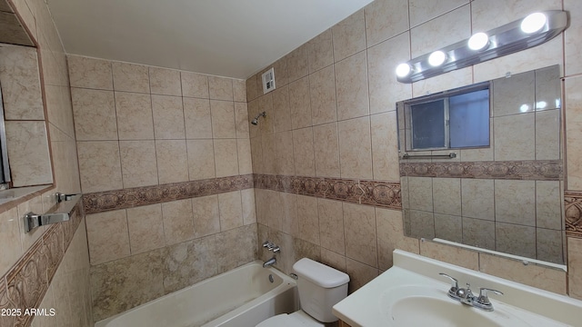 full bathroom with vanity, tiled shower / bath combo, and toilet