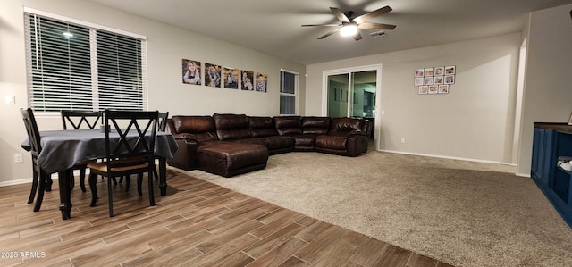 living area featuring ceiling fan, wood finished floors, visible vents, and baseboards