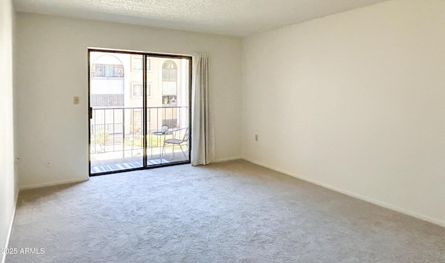 empty room with light carpet and a textured ceiling