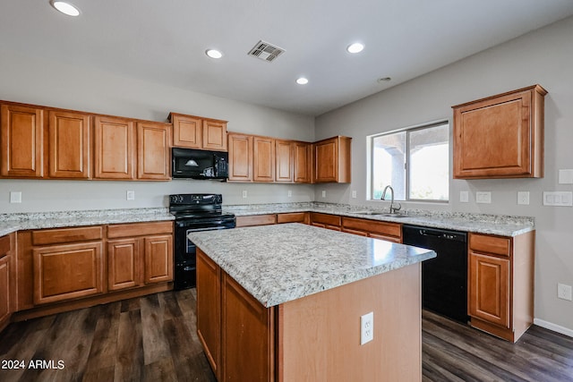 kitchen featuring black appliances, a kitchen island, sink, and dark wood-type flooring