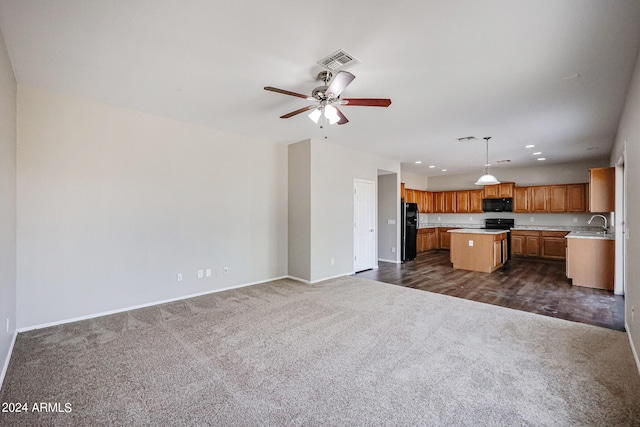 kitchen with black appliances, a center island, hanging light fixtures, dark colored carpet, and ceiling fan