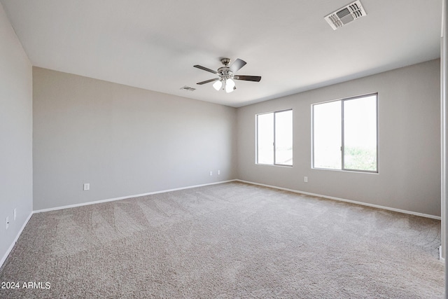 carpeted spare room featuring ceiling fan