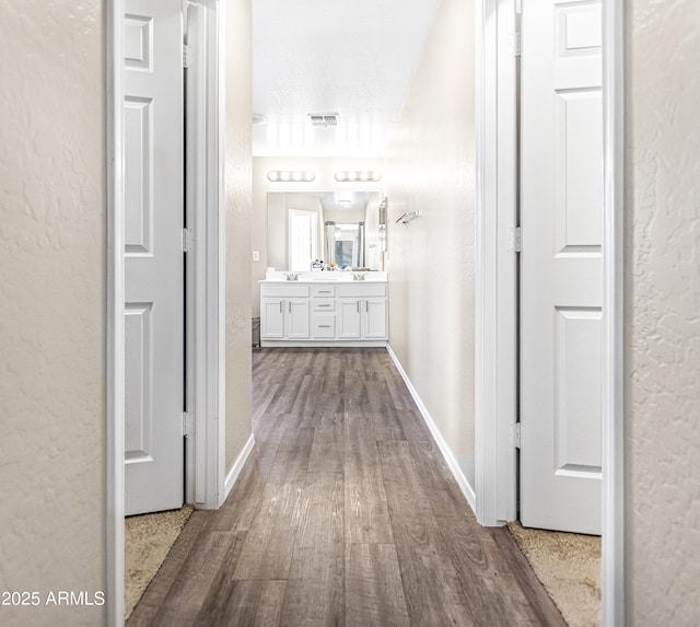 corridor featuring a textured ceiling and hardwood / wood-style floors