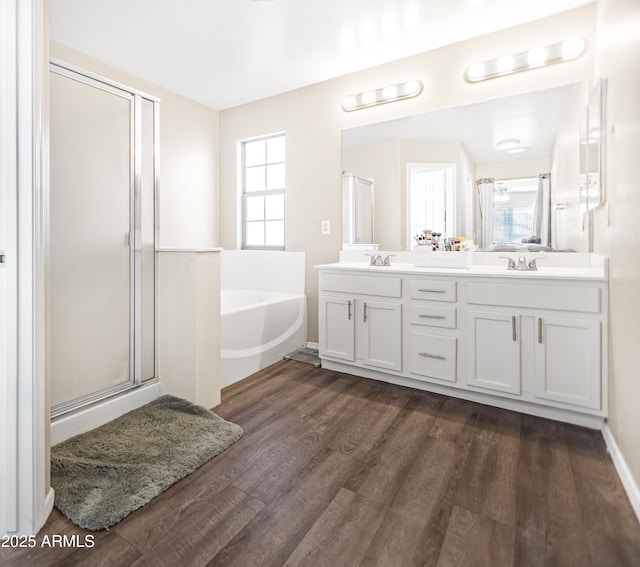 bathroom featuring independent shower and bath, hardwood / wood-style floors, and vanity