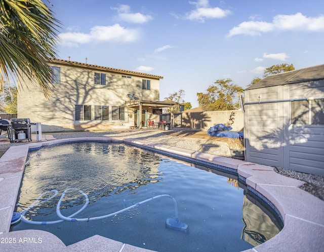 view of pool featuring a storage unit and a patio