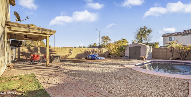 view of yard with ceiling fan, a fenced in pool, a storage shed, and a patio