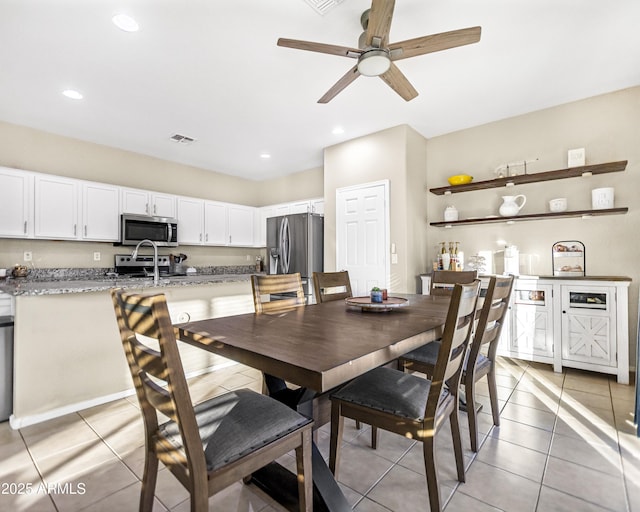 dining room with ceiling fan, sink, and light tile patterned floors