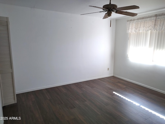 spare room with dark wood-type flooring and ceiling fan