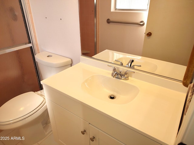 bathroom featuring vanity, toilet, and a shower with door