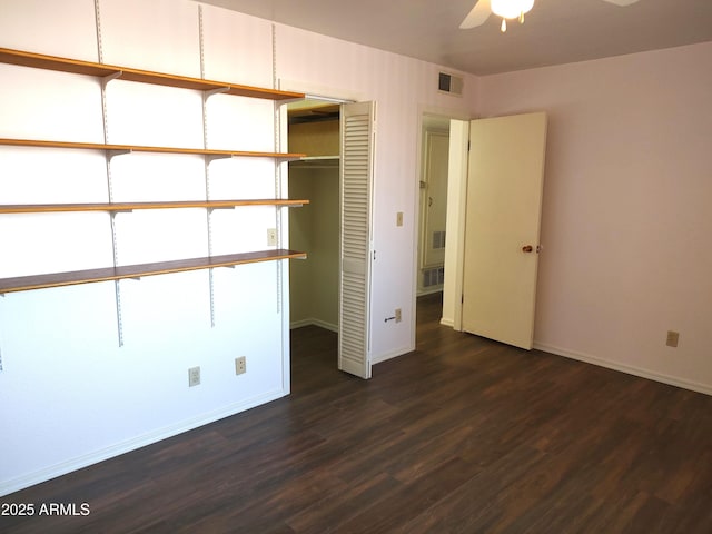 unfurnished bedroom with dark hardwood / wood-style flooring, a closet, and ceiling fan