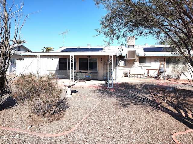 back of house with a patio, central air condition unit, and solar panels