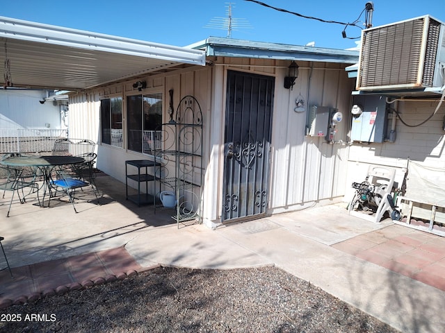 doorway to property with cooling unit and a patio area