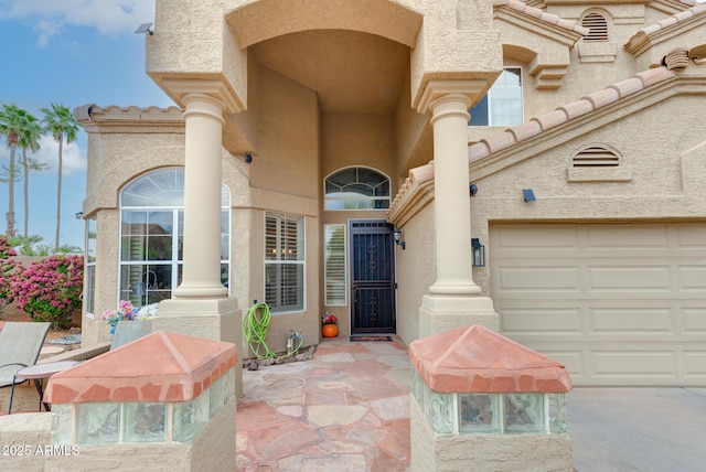 5940 W Robinson Way, Chandler, AZ 85226 - view of exterior entry with stucco siding, a garage, concrete driveway, and a tiled roof