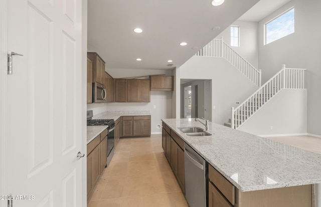17633 W Palo Verde Dr, Litchfield Park, AZ 85340 - kitchen featuring appliances with stainless steel finishes, light tile patterned floors, recessed lighting, light stone countertops, and an island with sink