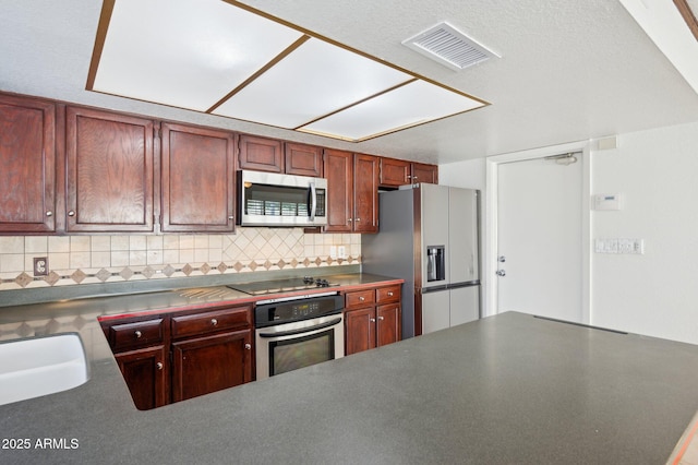 kitchen featuring appliances with stainless steel finishes, backsplash, and sink