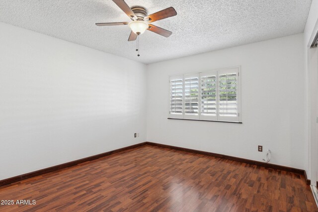 spare room with dark hardwood / wood-style flooring and ceiling fan