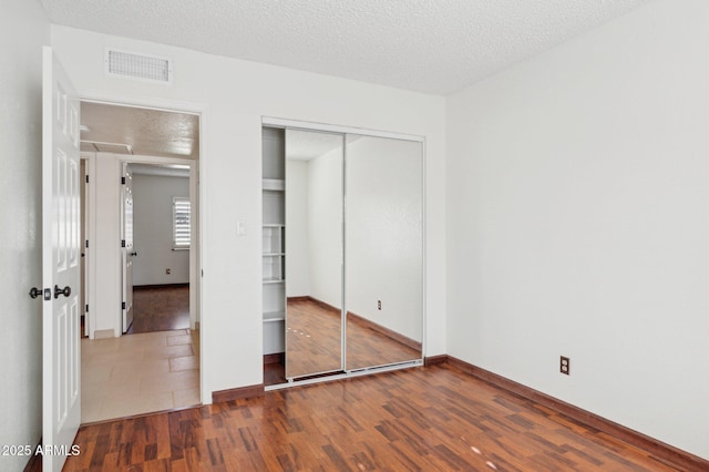 unfurnished bedroom with a textured ceiling and hardwood / wood-style floors