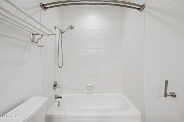 bathroom with toilet and tiled shower / bath combo