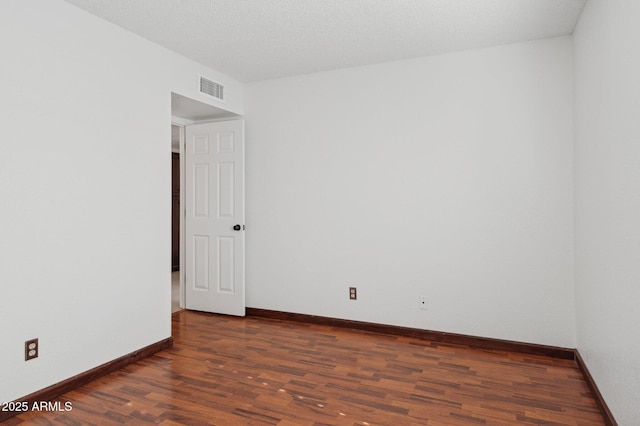 empty room with dark hardwood / wood-style flooring