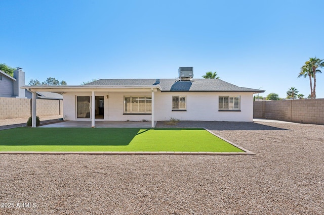 rear view of property with cooling unit, a patio area, and a yard