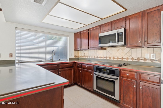 kitchen featuring sink, decorative backsplash, and appliances with stainless steel finishes