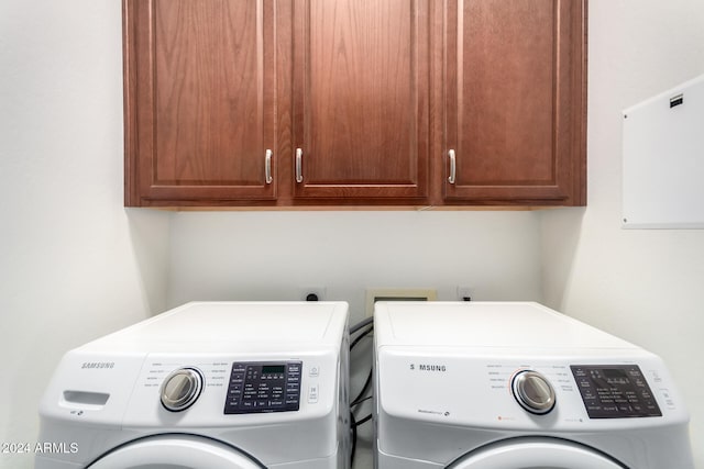 laundry room with cabinets and washing machine and clothes dryer