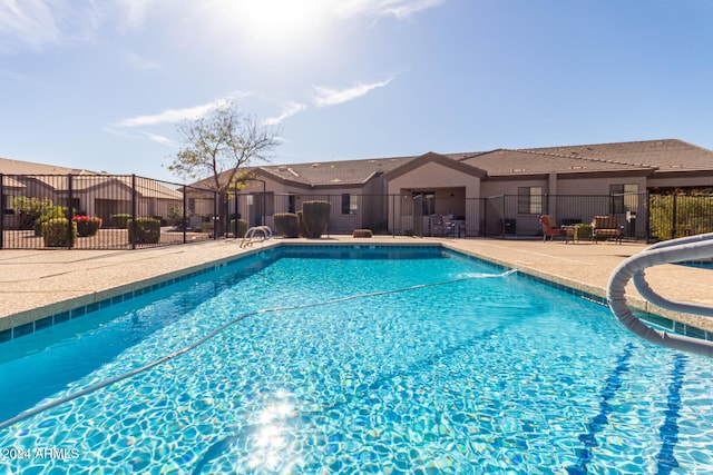 view of pool with a water slide and a patio