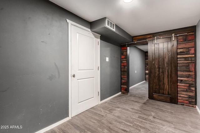 8542 N 30th Dr, Phoenix, AZ 85051 - basement with a barn door, wood finished floors, and baseboards
