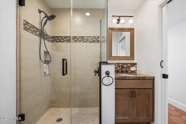 bathroom featuring vanity, tasteful backsplash, and a shower with door