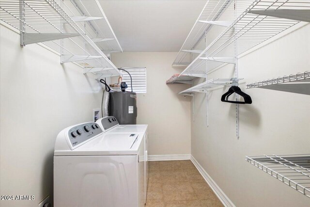 washroom featuring independent washer and dryer, water heater, and light tile patterned floors