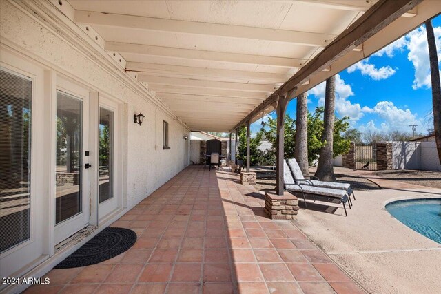 view of swimming pool featuring a diving board and a patio