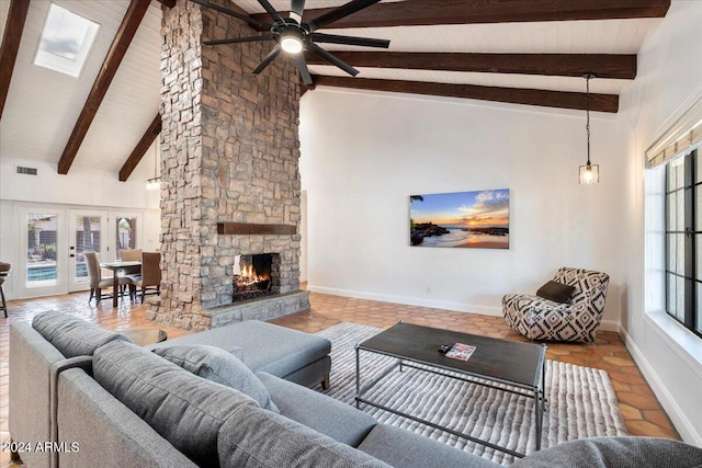 living room featuring french doors, beam ceiling, a stone fireplace, ceiling fan, and high vaulted ceiling