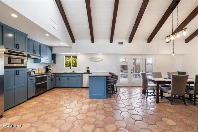 kitchen featuring light tile patterned flooring, a kitchen bar, french doors, stainless steel appliances, and blue cabinetry