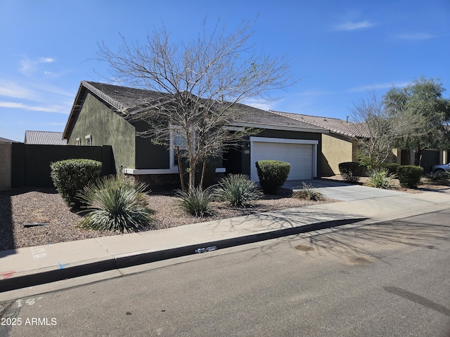 view of front of property with stucco siding, a garage, and driveway