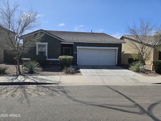 single story home with stucco siding, a garage, concrete driveway, and a tile roof