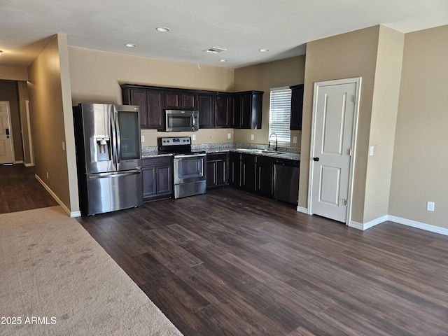 kitchen with visible vents, dark wood-type flooring, a sink, appliances with stainless steel finishes, and baseboards