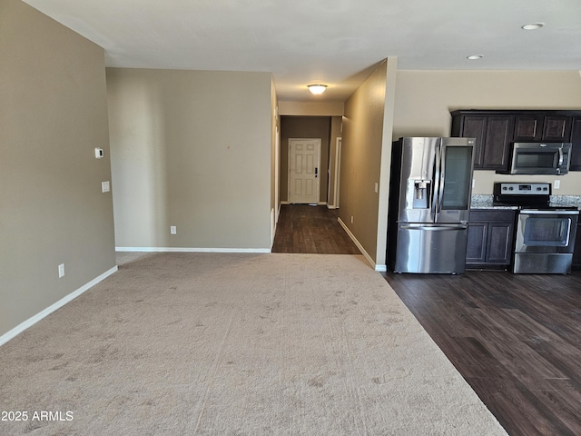 kitchen with dark wood-type flooring, baseboards, and stainless steel appliances