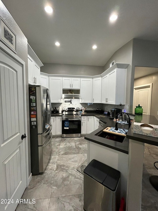 kitchen featuring backsplash, kitchen peninsula, white cabinetry, and stainless steel appliances