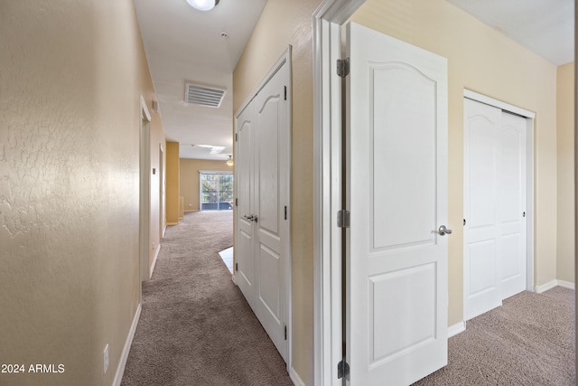 hall featuring dark colored carpet