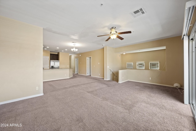 unfurnished living room with carpet and ceiling fan with notable chandelier