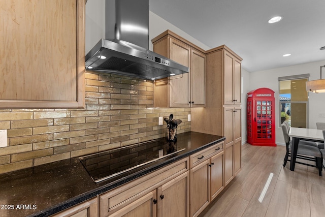 kitchen featuring black electric cooktop, light wood-type flooring, wall chimney range hood, backsplash, and recessed lighting