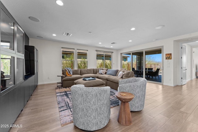 living room featuring baseboards, light wood-type flooring, visible vents, and recessed lighting